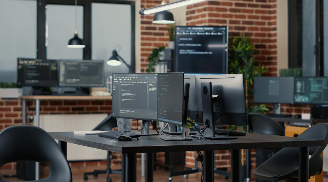 computer screens with programming code on the table in office