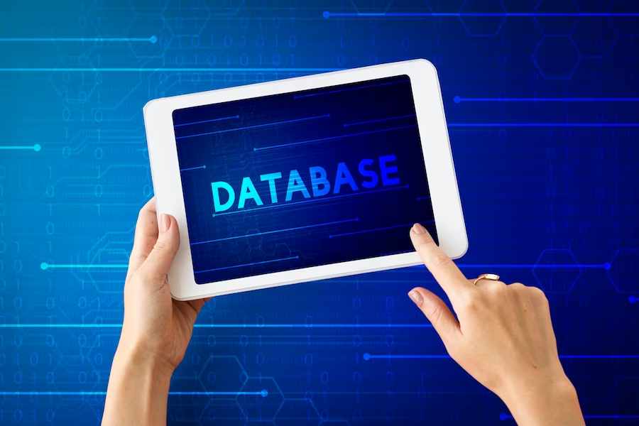 A hand holding a tablet displaying the text "database" on its screen